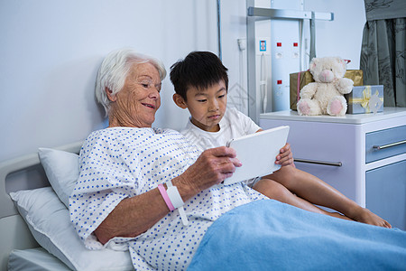 持有数字平板电脑的高级病人和男孩药物治疗孩子治疗女性医疗医务室服务互联网智力诊所图片
