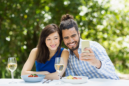夫妻在手机上拍自拍的男性女士饮料餐厅顾客男人服装闲暇休闲触摸屏图片
