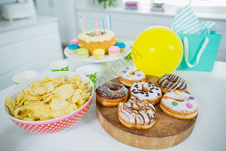 甜甜圈 薯片 生日蛋糕和桌上的气球糕点家庭纸袋生日厨房蛋糕架礼物桌子闲暇蜡烛图片