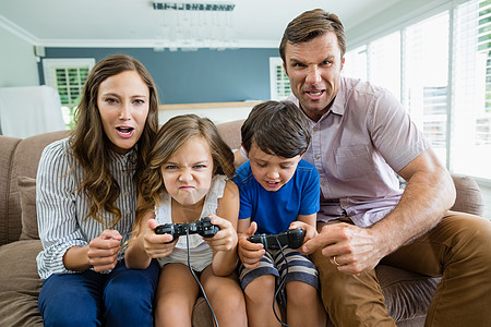 幸福的家庭一起在客厅玩电子游戏女性女儿沙发公寓住所女孩男人享受生活遥控图片