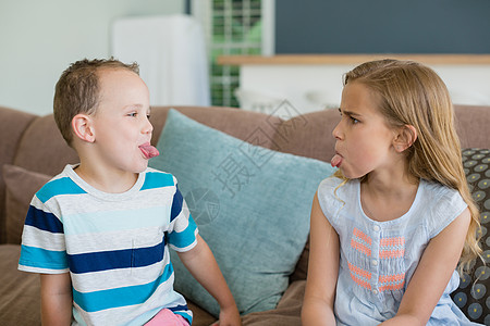 姐姐和哥哥在客厅的沙发上用舌头对着对方伸出舌头烦躁专注现实男性娱乐微笑享受女性援手休闲图片