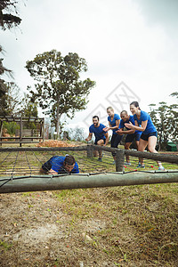 适合在障碍赛中爬到网下的人 同时适合人们欢呼女性运动服军营活动福利耐力木头军事专注训练图片