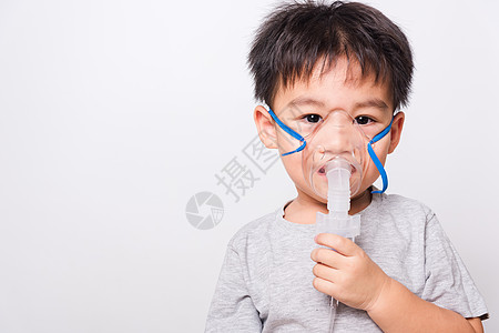 近距离的亚洲脸孔 小男孩生病了 他用蒸汽水药品孩子们男生病人支气管炎保健医院面具药物空气图片