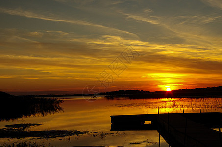 日落时在湖边的脚桥 太阳反射图片