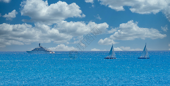 两艘帆船和蓝地平线上的游艇图片