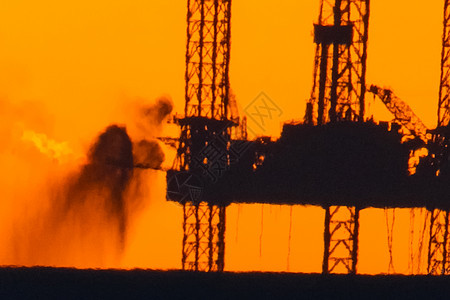 日落时用燃烧的火炬筑起石油平台 在港口钻井平台上倾斜钻头植物海景船运橙子运输天空勘探力量活力图片