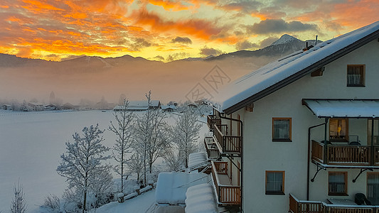 雪山上日出 德国人看着建筑 面对红天和黄天天气蓝色薄雾仙境房子世界场景旅游全景天空图片