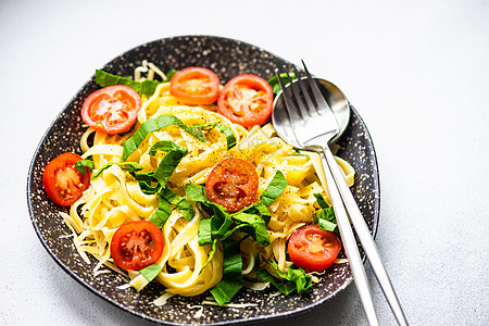 加菠菜和番茄的意大利面粉面条桌子健康西红柿食物菠菜草本植物石头美食盘子图片
