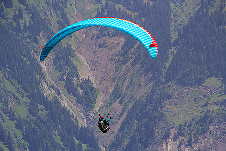 正在向高山的某处滑翔跳伞员男人自由运动跳伞飞行空气危险高度速度图片
