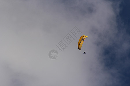 正在向高山的某处滑翔自由跳伞降落伞头盔航班高度男性爱好活动天空图片