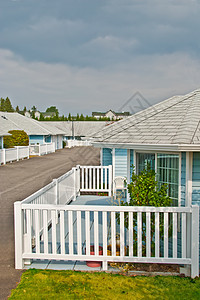 院子甲板上有椅子和装饰树的住宅房图片