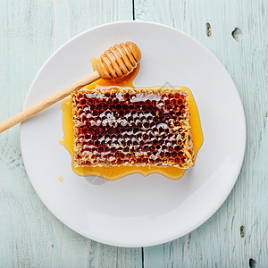 蜂蜜在白色盘子上 带有蜂蜜花蜜梳子味道饮食治疗食物美食蜂窝糖浆养蜂业图片