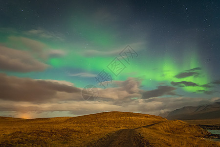 在冰岛北部灯光照耀着亮光束冰川小路星星天空横梁北极星蓝色极光月亮远足图片