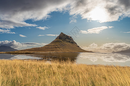 Kirkjufell 冰岛著名的山峰 在阳光晴朗的日光中在湖中反射图片