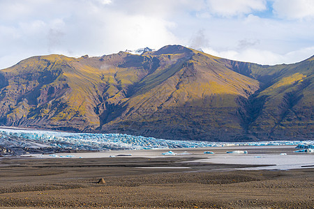 冰川 在冰岛深蓝色冰层 前面的山峰过度生长图片