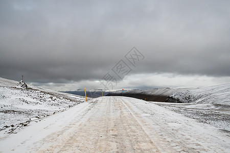 雪后风景在秋天和暴风天气中 冰岛西湾的雪覆盖山口背景