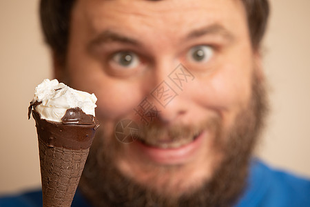 男人在部分吃过冰淇淋锥子的幕后微笑高清图片