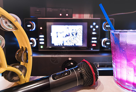卡拉OK俱乐部的黑色麦克风 有遥控器唱片享受设备蓝色爱好苏打演讲录音黑胶流行音乐会图片