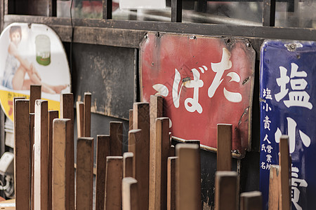 旧旧古老的日本金属标志和红稻纸板面条隧道标语通道时代阴影桌子火车行人框架图片