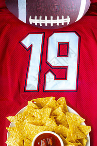 一个美国足球 配有有机玉米薯片 和温柔的萨尔萨加 在白色红球衣上图片