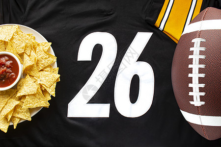 一个美国足球 配有有机玉米片和 白色黑色球衣上的轻度萨尔萨 26个数字在水平视线上图片