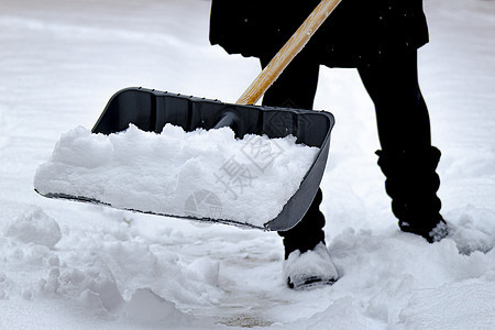 女性在冬天用铁铲铲铲雪 在满是雪图片