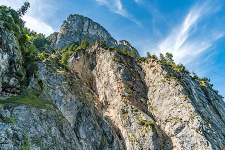 徒步和爬上泰格尔堡高山蓝色松树远足运动登山者太阳草地岩石顶峰图片