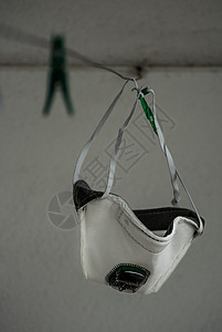 白色医疗面罩和绿色空气过滤器挂在衣绳上图片