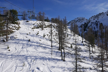 冬季高阿尔卑斯山的蒙金维尔雪雪地太阳滑雪山脉全景首脑小木屋松树假期缆车雪人图片