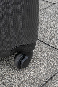 混凝土质地地面上的轮式行李旅行袋手提箱楼板轮子车轮街道行李轮旅行黑色旅行包配饰图片
