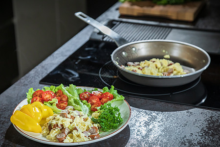 灰色桌上有草药和蔬菜的奥米利特洋葱白色菜单绿色午餐盘子早餐黄色红色油炸图片