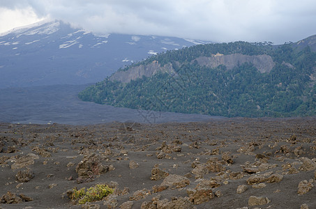 坚固的熔岩和Llaima火山田 周围都是背景中的云层图片