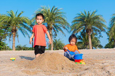 哥哥和妹妹两个孩子玩挖沙子玩玩具的滑稽挖掘女孩兄弟乐趣男生活动假期太阳童年家庭幸福图片