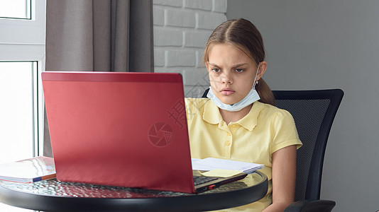 自孤立模式的女孩坐在电脑上 在网上做功课 校对 Portnoy图片
