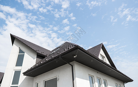 覆盖有瓷砖效果 PVC 涂层棕色金属屋顶板的现代屋顶材料平铺黏土橙子建筑学陶瓷房子住宅技术天空图片
