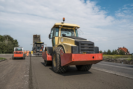 开车出行用于道路维修的沥青路面黄色红色重型振动压路机 在新的道路施工现场工作 修复车轮滚筒运输柏油终结者振动器装载机街道车道工程背景