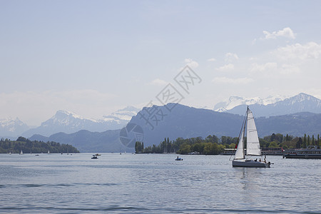雪前的船覆盖了瑞士中部卢塞恩湖上的阿尔卑斯山峰 该船沿湖航行旗杆旅游旅行蓝色日落全景天鹅高山旗帜观光图片