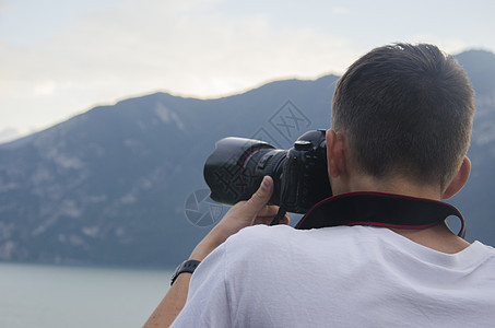 特写摄影师在意大利阿尔卑斯山的日落时分拍照 美丽的夕阳笼罩着高山 拍他最好的照片的年轻摄影师女孩相机背包摄影远足悬崖天空冒险顶峰图片