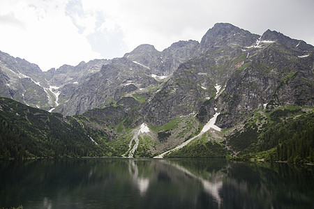 美丽的夏日高山湖景覆盖着绿树和天空中的阳光 山在水中的倒影 水晶般清澈的水 欧洲 阿尔卑斯山太阳蓝色山脉旅行荒野风景运动岩石艺术图片