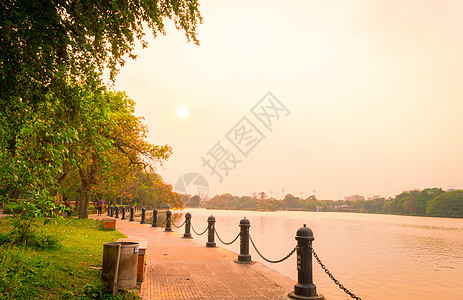 夏天傍晚的湖边公园 日落阳光照亮的花园小径公园车道 风景场景中的红色和橙色 夕阳西下 Dhakuria 湖镇 加尔各答 西孟加拉图片