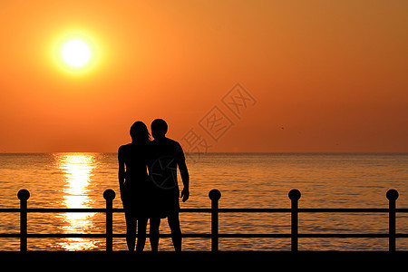 黎明时分在海滨的一对夫妇休整图片