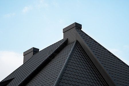黑色金属瓦屋顶 屋顶金属板 现代类型的屋顶材料 屋瓦的屋顶映衬着蓝天 建筑建筑学窗户床单房子天空阳光工作蓝色阁楼控制板图片