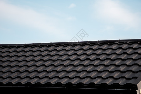 棕色金属瓦屋顶 屋顶金属板 现代类型的屋顶材料 屋瓦的屋顶映衬着蓝天 建筑角落房子蓝色工作建筑学控制板床单建造窗户天空图片