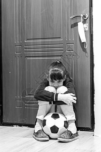 女孩坐在前门 带着球坐着 但在隔离期间不准她出去 (b) 禁止进入;图片