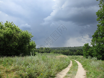 暴风雨中田野中的公路天空草地雷雨农场风景戏剧性小路地平线农业农村图片