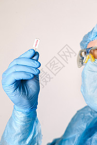 特写医生手拿着疫苗 医用器材 一名医生佩戴个人防护设备 包括面罩 护目镜和防护服 以保护 COVID 冠状病毒感染样本医院疾病技图片