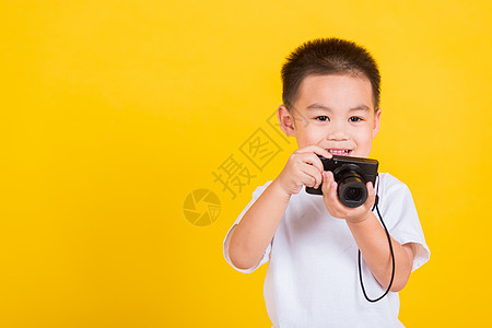 男孩拿着照相摄影机 拍照片时要用摄像快乐记者冒充孩子技术教育职业摄影乡愁男人图片