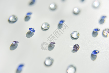 白色背景上不同颜色的闪光石工作室石头紫色珠宝水晶桌子火花玻璃水钻钻石图片