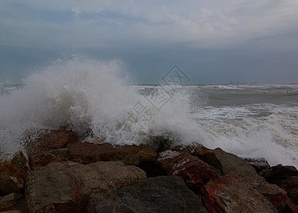 沙滩上波浪的断裂雷雨地平线戏剧性天空蓝色海岸线海浪海景气旋岩石图片