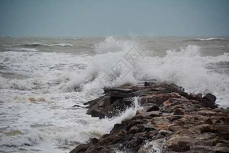 沙滩上波浪的断裂地平线灯光全景力量旅行蓝色岩石天气戏剧性灯塔图片